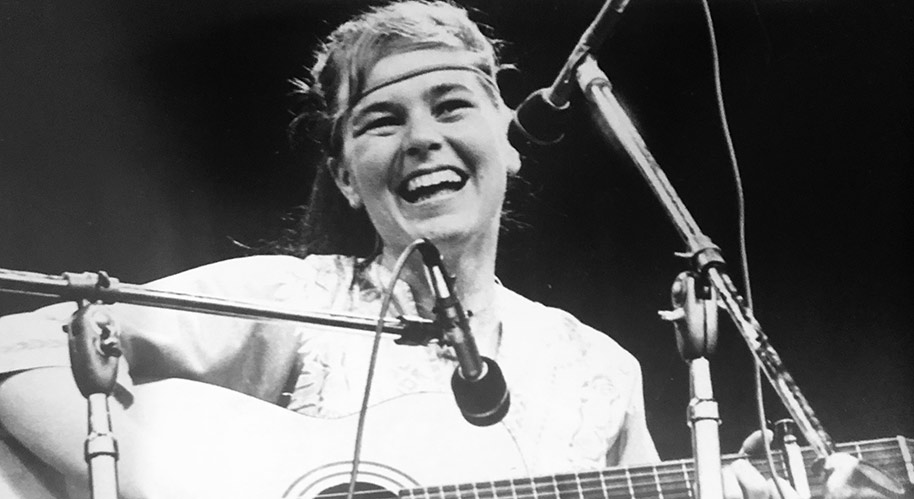 Vintage photo of Edith Butler on stage with guitar at a music festival